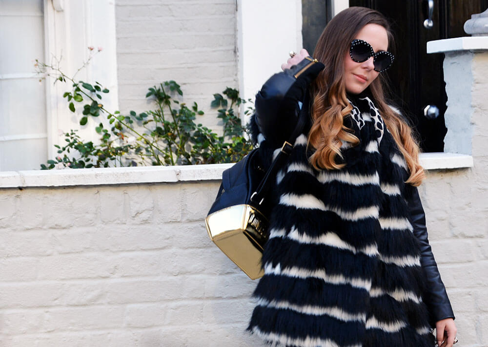 Edita in Biba coat, HM jeans, Cesare Paciotti, Moschino backpack, D&G glasses